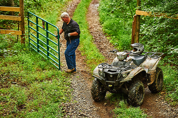 man on ATV moving gate